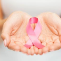 Hand holding breast cancer awareness ribbon
